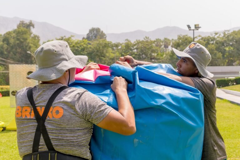 Equipo de Brinko cargando y armando un inflable azul